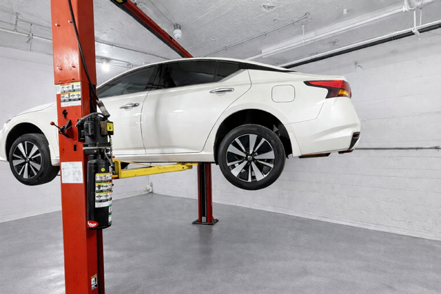 Vehicle on two post lift, rear quarter view