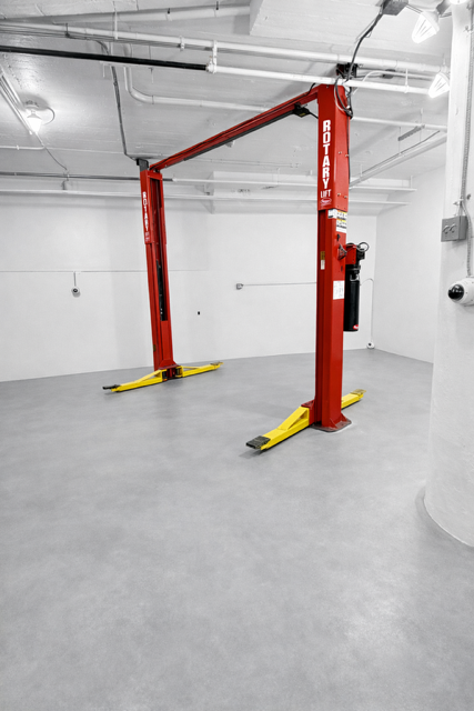 Two-post lift lowered, vehicle positioned for inspection